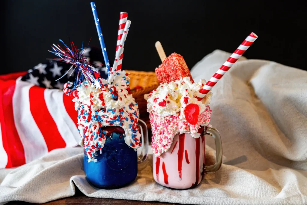 America 250 celebration shakes topped with whipped cream, sprinkles, straws, and sweet treats.