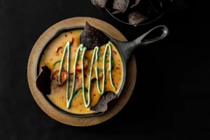 Hot queso, jalapeños and avocado crema, served with dark tortilla chips.