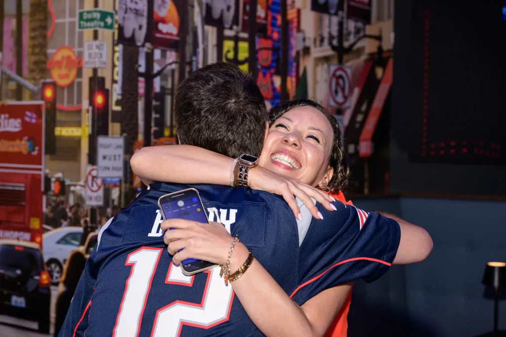 Guests embracing during a sports viewing party at Planet Hollywood NYC