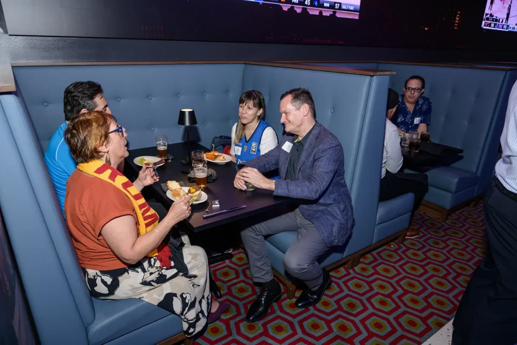 Guests socializing in a booth during an event at Planet Hollywood NYC